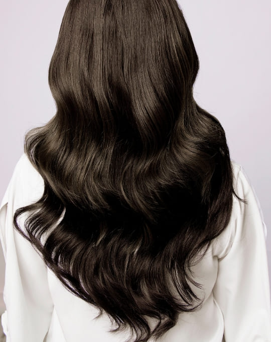 黒髪のロングヘアーでパーマがかかっている女性